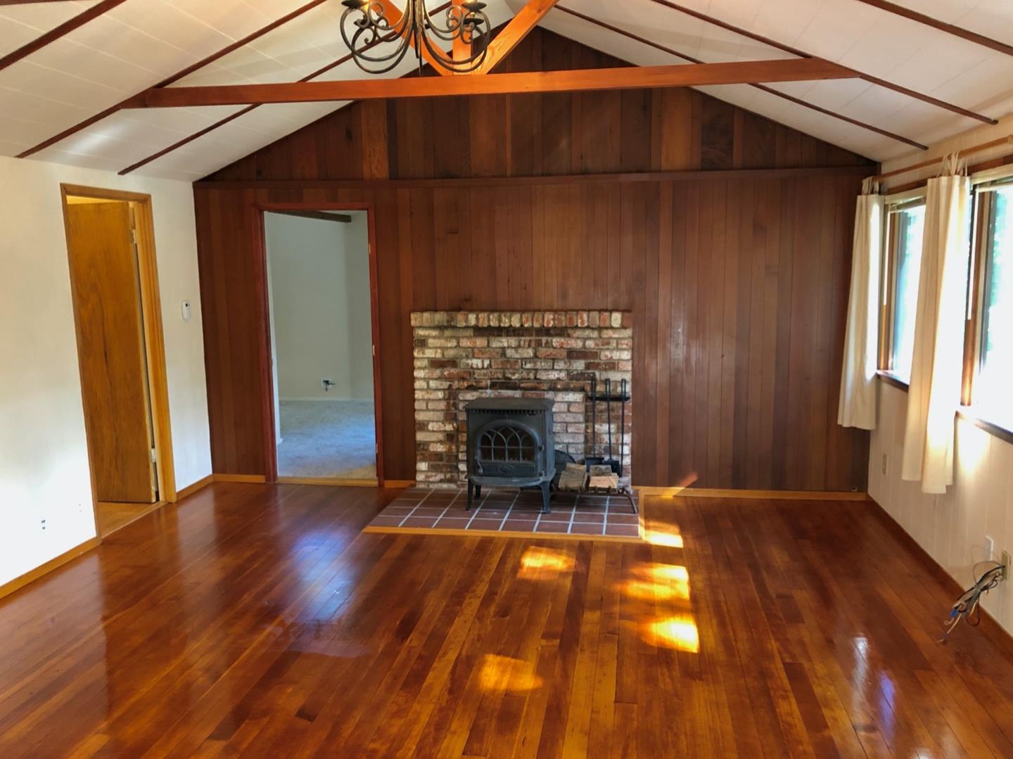 187 Chapman Road Woodside, CA 94062 - Photo 4 of 29 an empty room with wooden floor fireplace and windows