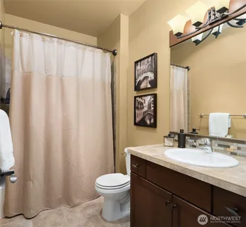 a bedroom with a bed and painting on the wall