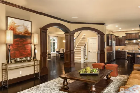 a living room with furniture a fireplace and a dining table with wooden floor