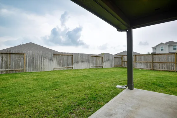 a view of a backyard with wooden fence