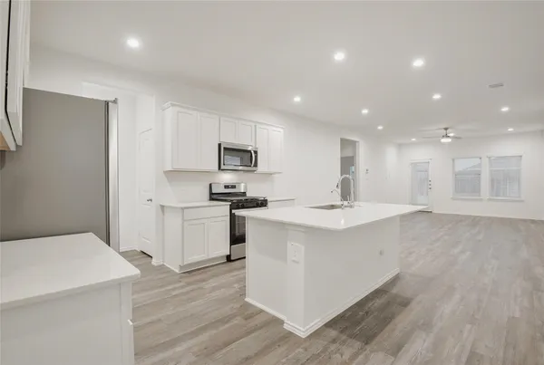 a kitchen with a sink window and stainless steel appliances