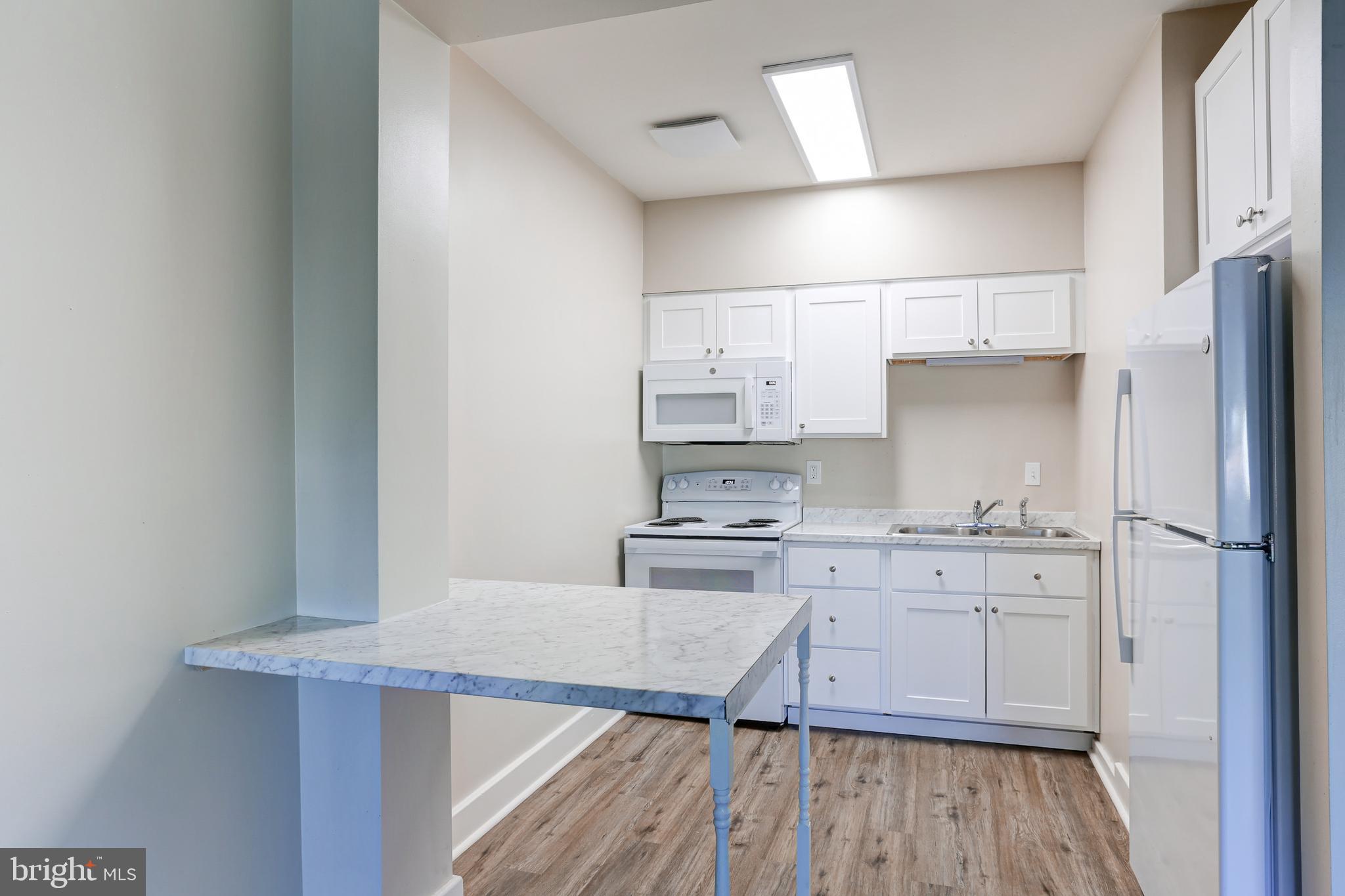 310 Bridge Street, Unit A New Cumberland, PA 17070 - Photo 4 of 7 a kitchen with stainless steel appliances a stove refrigerator sink and cabinets