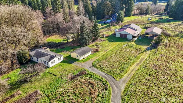 an aerial view of a house with a garden and lake view