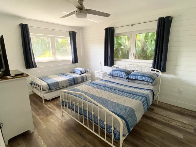 a bedroom with two beds and a flat screen tv