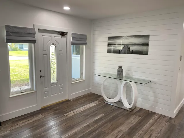 a view of a livingroom with wooden floor and windows