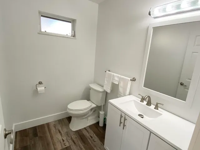 a bathroom with a sink toilet and a mirror