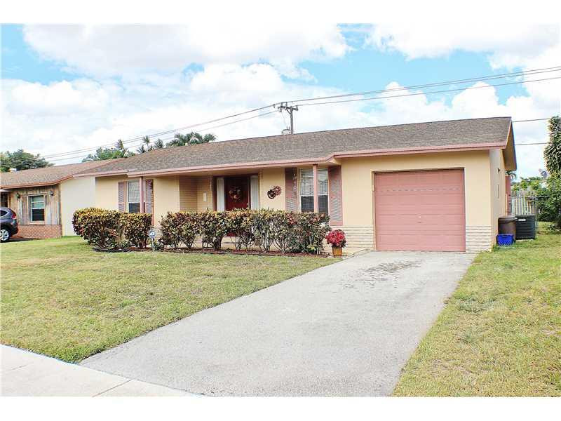 22170 Southwest 64th Way Boca Raton, FL 33428 - Photo 1 of 17 a front view of a house with a yard and garage