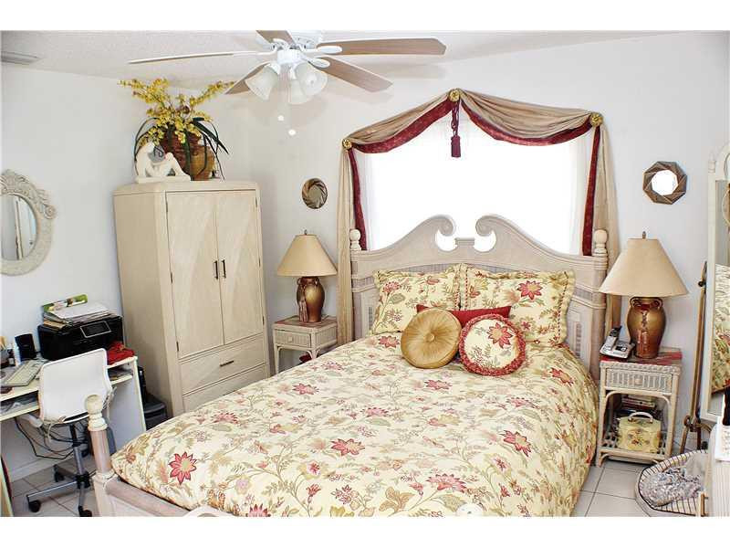 22170 Southwest 64th Way Boca Raton, FL 33428 - Photo 10 of 17 a bedroom with a bed and dresser with mirror