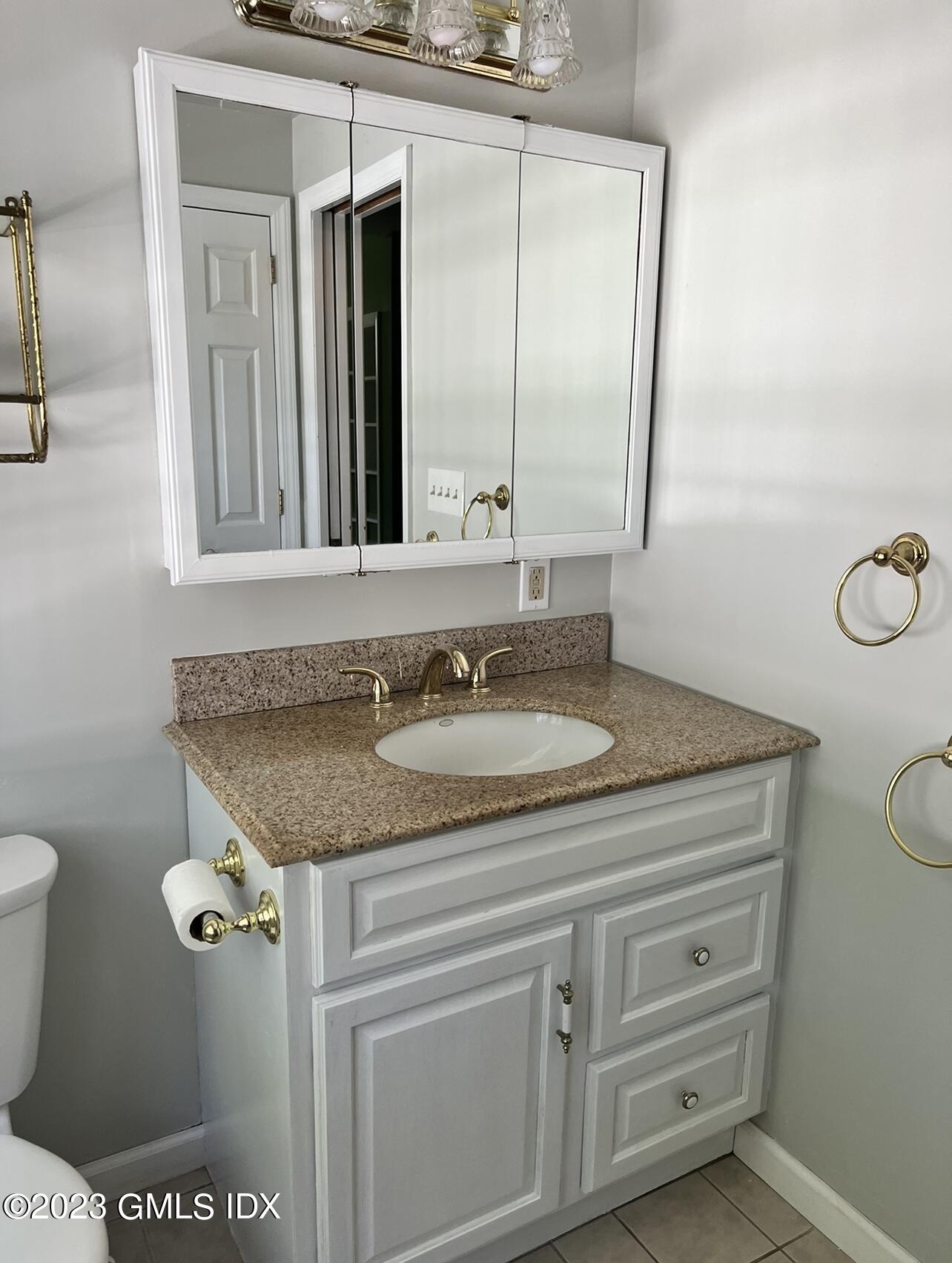 5 Tory Road Riverside, CT 06878 - Photo 15 of 26 a bathroom with a granite countertop sink a toilet and a mirror
