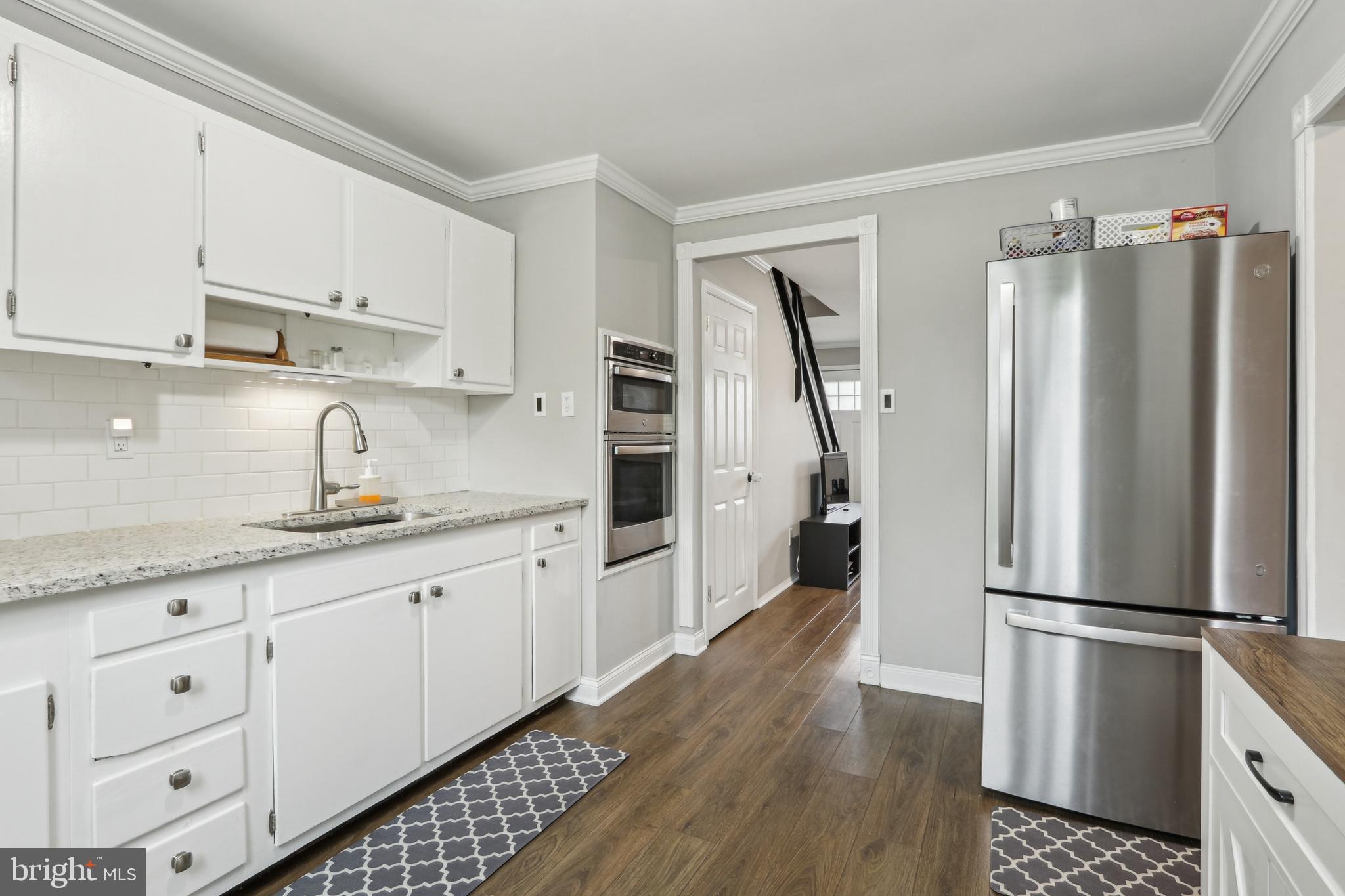 3207 Fairdale Road Philadelphia, PA 19154 - Photo 9 of 49 a kitchen with granite countertop a refrigerator sink and white cabinets