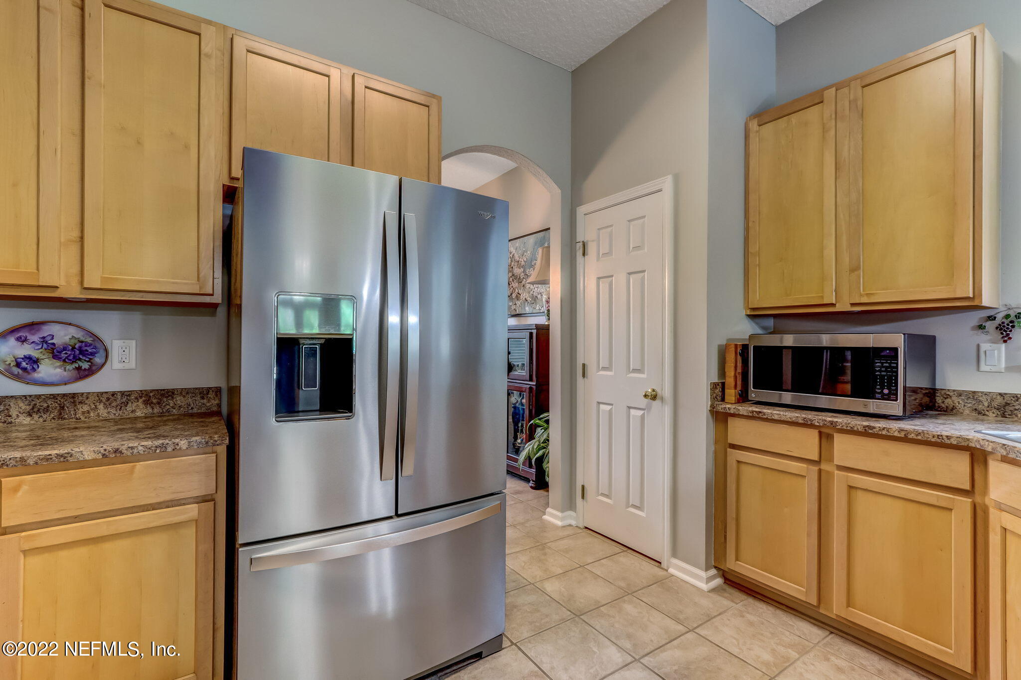96692 Commodore Point Drive Yulee, FL 32097 - Photo 9 of 38 a kitchen with stainless steel appliances granite countertop a refrigerator a microwave and cabinets