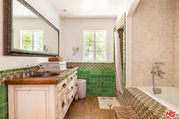 a bathroom with a sink a mirror and a bathtub