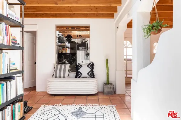 a view of a bedroom with wooden floor and a potted plant
