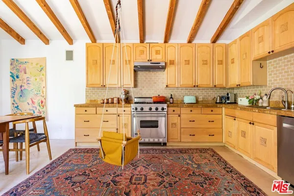 a kitchen with stainless steel appliances a stove a sink and a cabinets