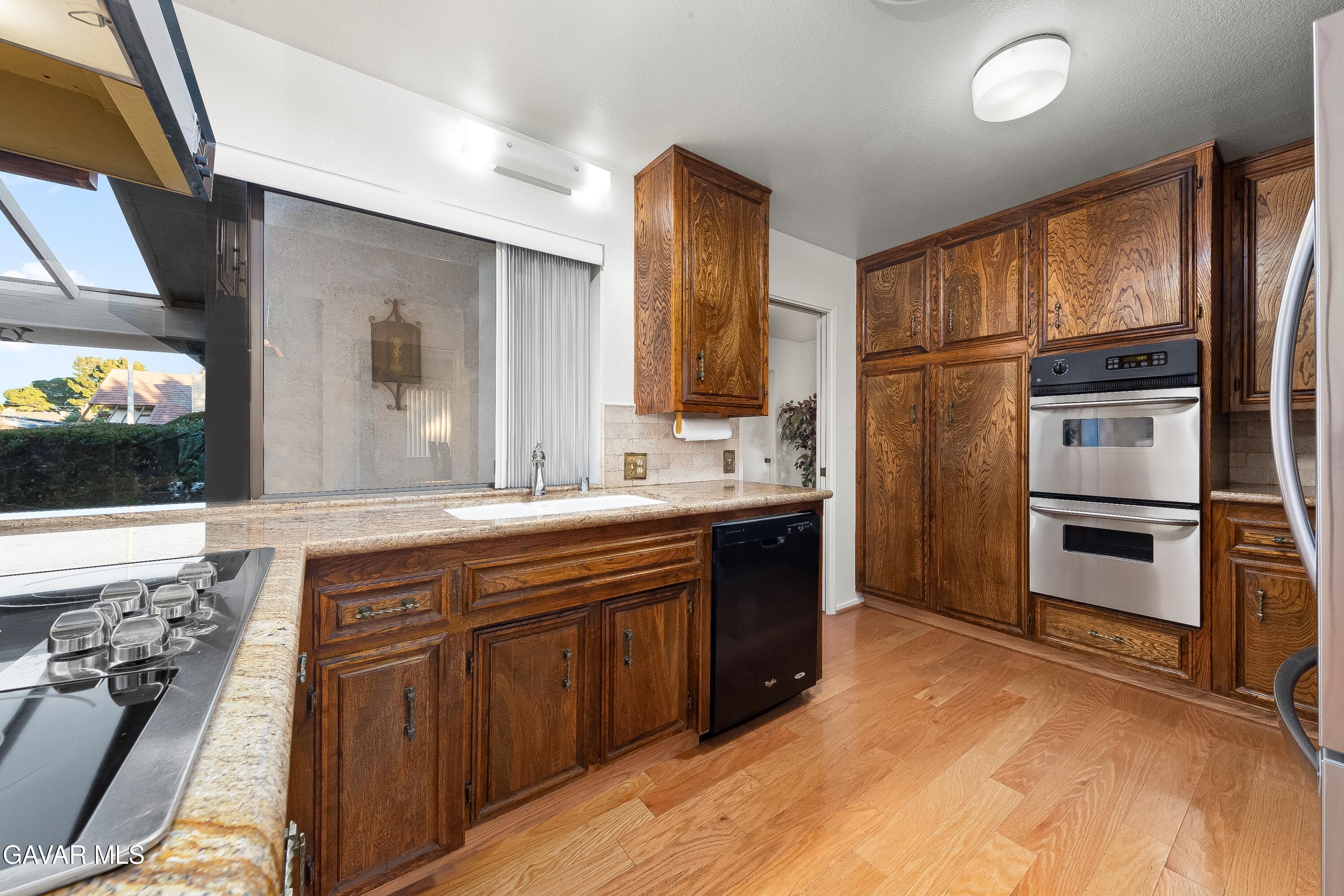 43755 Sentry Lane Lancaster, CA 93536 - Photo 11 of 36 a kitchen with stainless steel appliances granite countertop a refrigerator and a stove top oven
