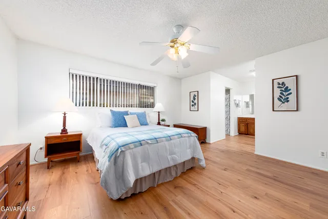 a spacious bedroom with a bed and a chandelier