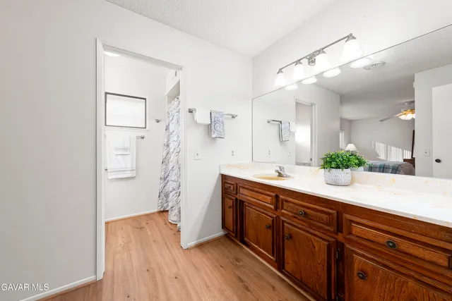a spacious bathroom with a granite countertop sink mirror and shower