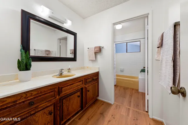 a bathroom with a double vanity sink a mirror and a bathtub