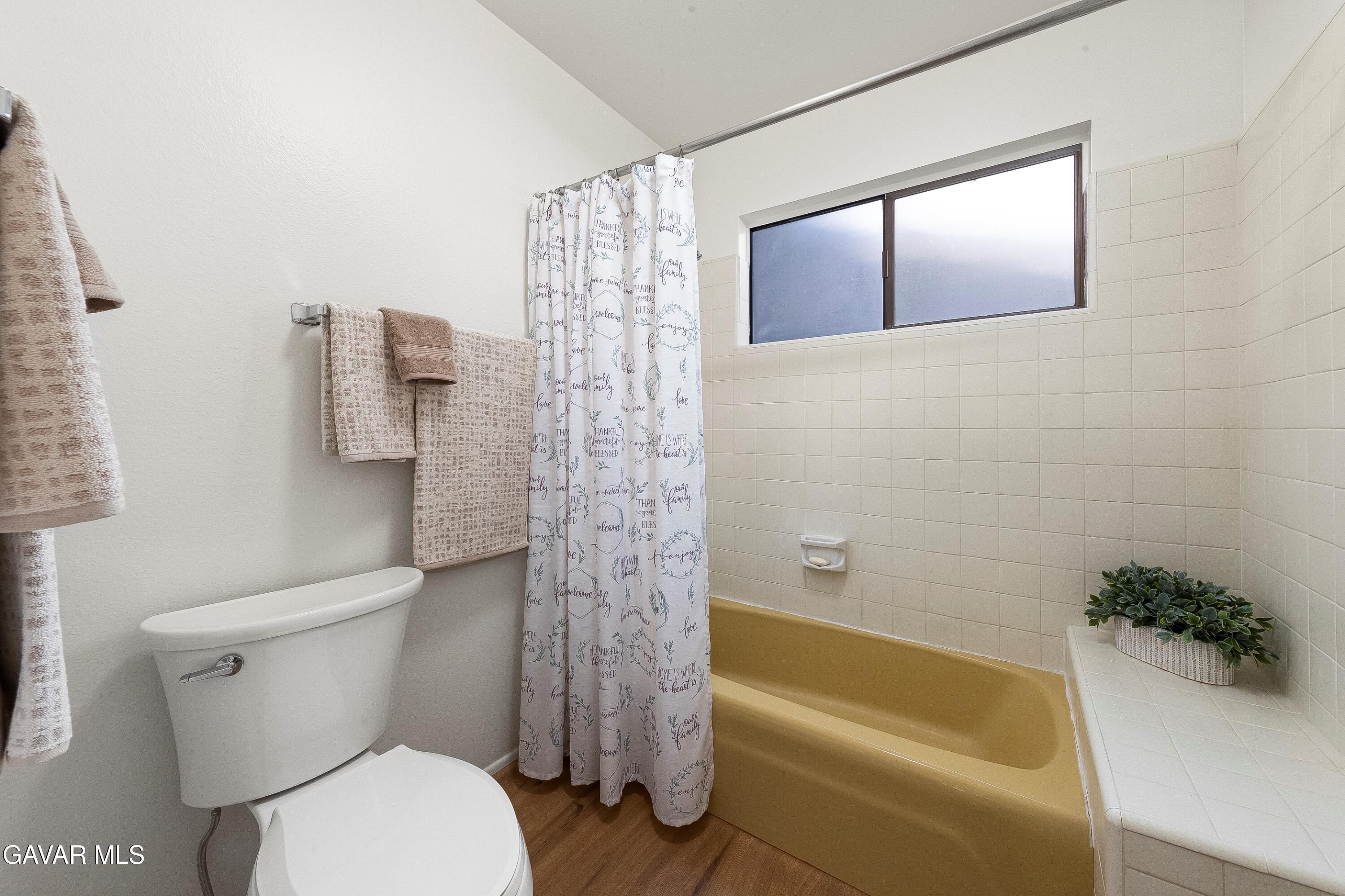 43755 Sentry Lane Lancaster, CA 93536 - Photo 23 of 36 a bathroom with a toilet and a bathtub