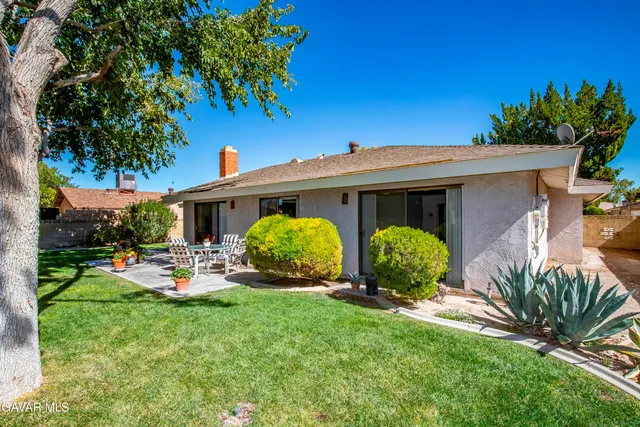 a view of a house with backyard sitting area and garden