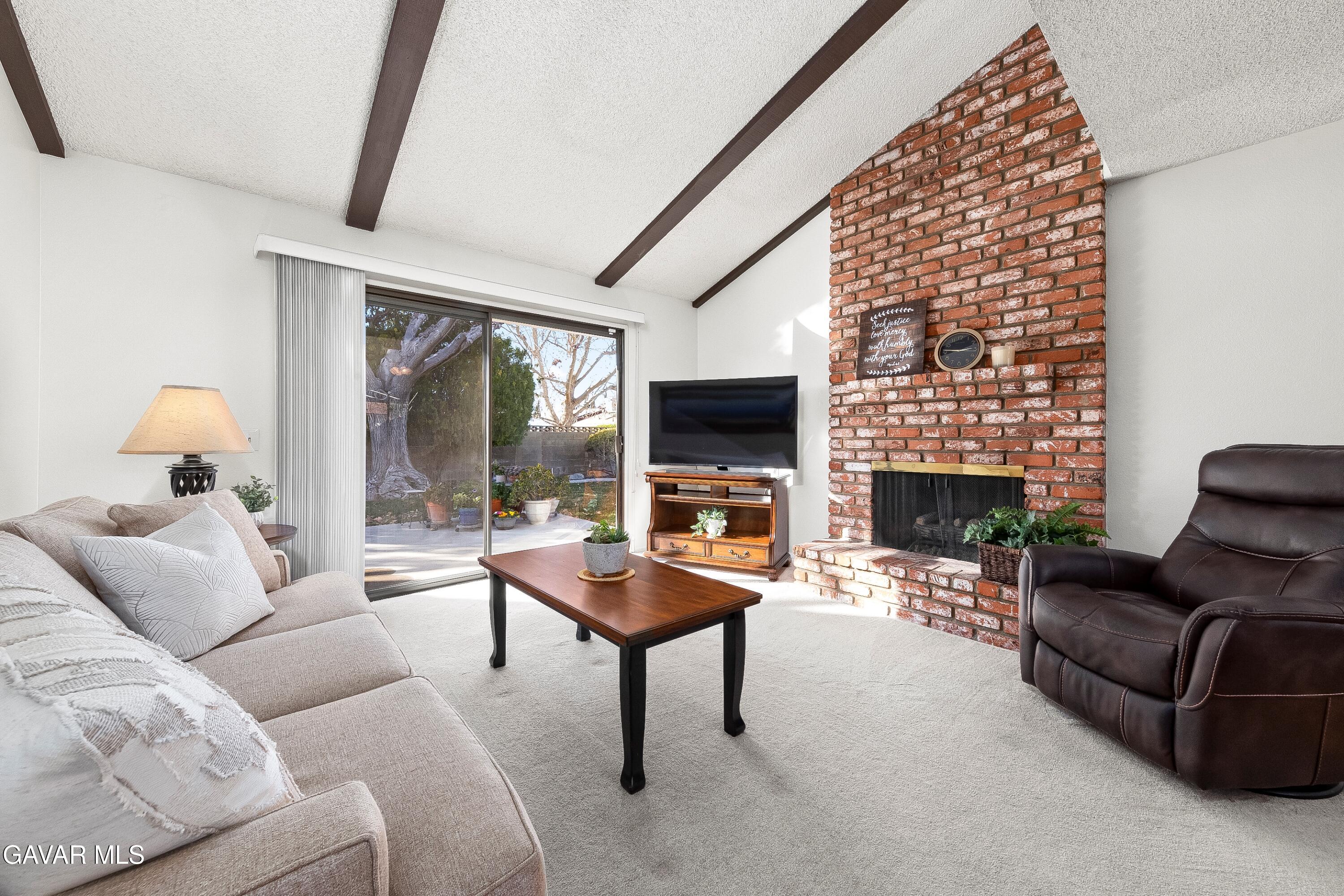 43755 Sentry Lane Lancaster, CA 93536 - Photo 8 of 36 a living room with furniture a fireplace and a flat screen tv