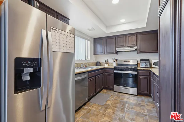 a kitchen with a sink stove top oven and cabinets