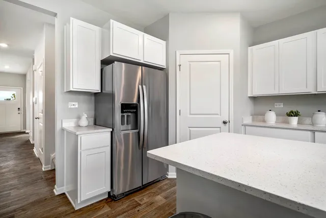 a kitchen with a refrigerator a sink and cabinets