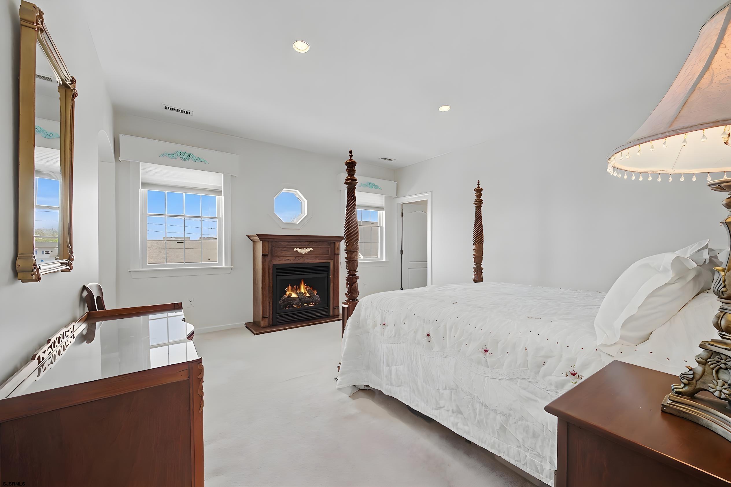 212 17th Street South Brigantine, NJ 08203 - Photo 22 of 37 a spacious bedroom with a bed and a fireplace