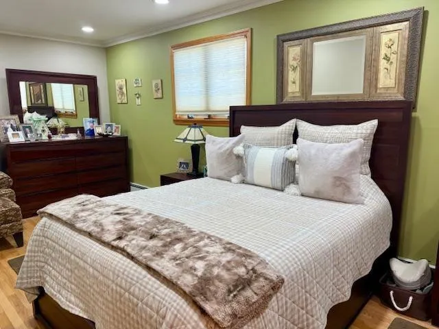 a bedroom with a bed and wooden floor