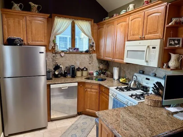 a kitchen with stainless steel appliances granite countertop a refrigerator sink and cabinets