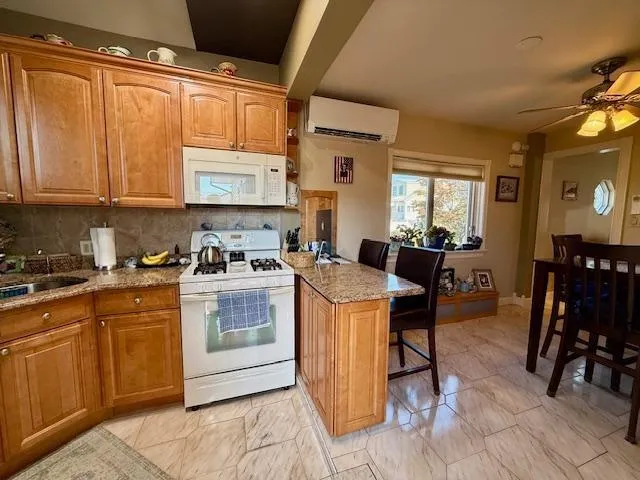 a kitchen with stainless steel appliances granite countertop a table chairs and a refrigerator