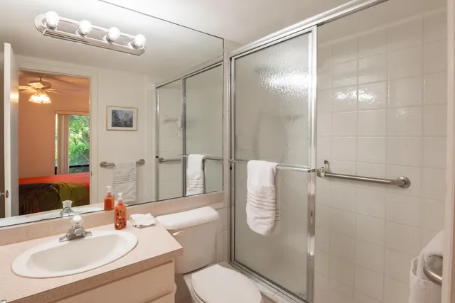 a bathroom with a sink a toilet and shower