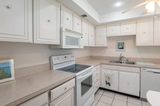 a kitchen with cabinets appliances a sink and a counter