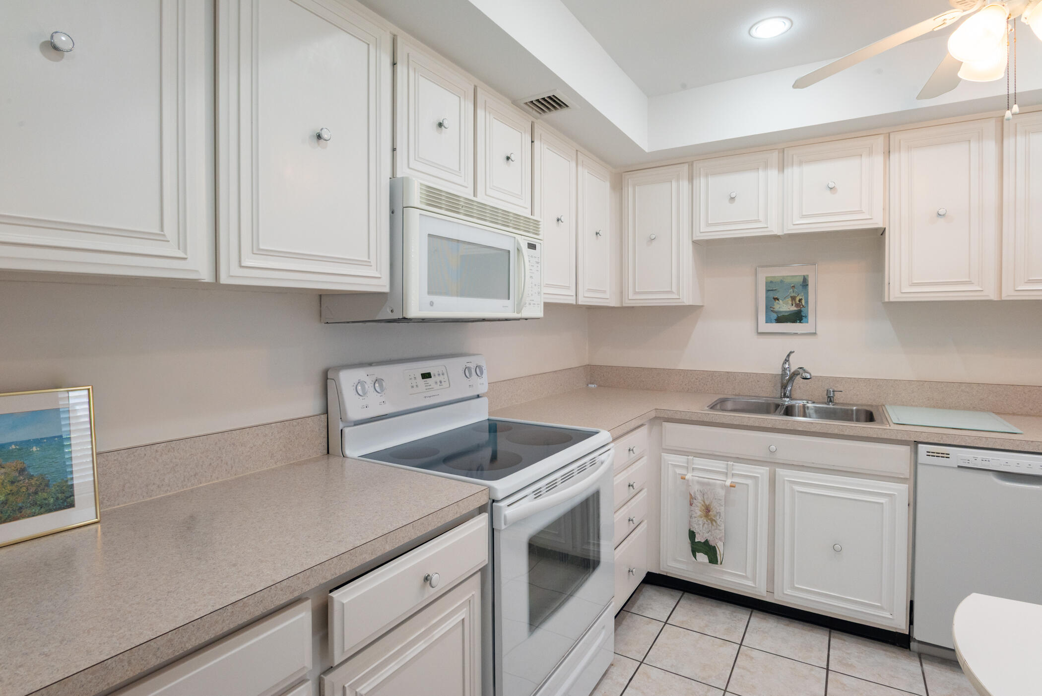 2550 Presidential Way, Unit 107 West Palm Beach, FL 33401 - Photo 20 of 28 a kitchen with cabinets appliances a sink and a counter