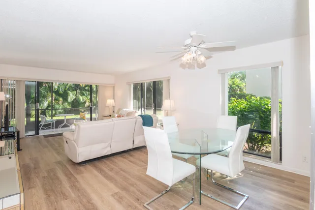a living room with couches a coffee table and a chandelier