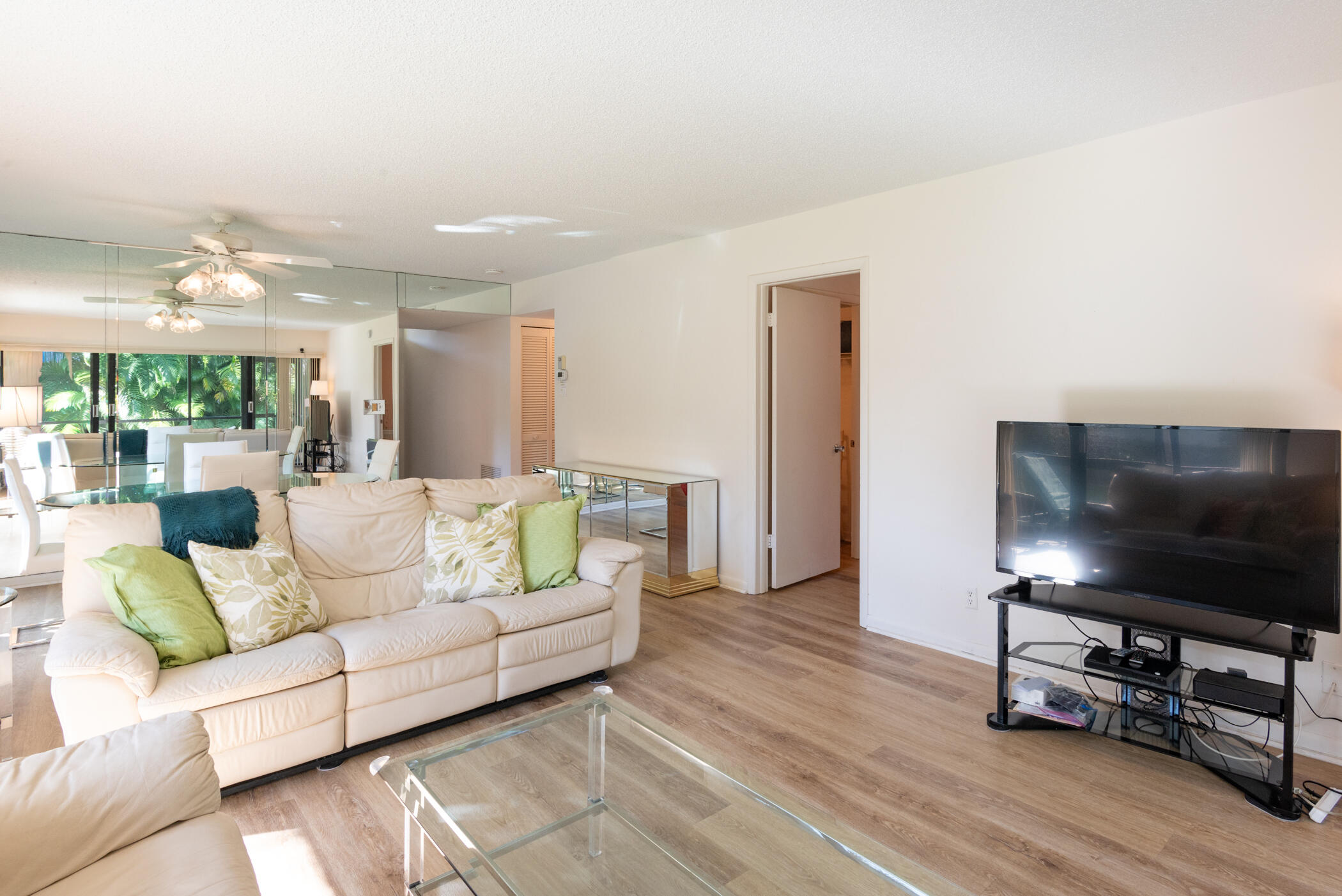 2550 Presidential Way, Unit 107 West Palm Beach, FL 33401 - Photo 8 of 28 a living room with furniture and a flat screen tv