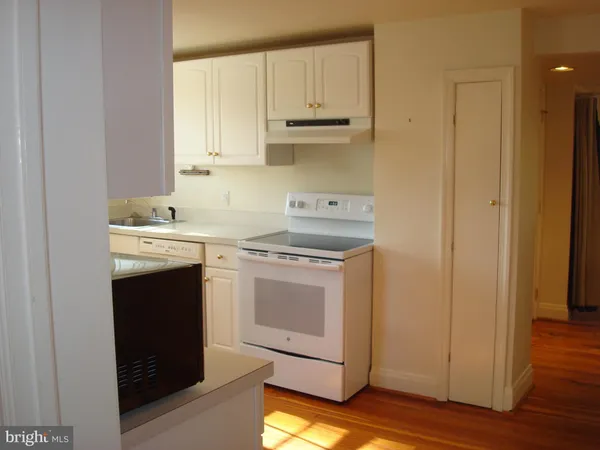 a kitchen with a stove sink and cabinets