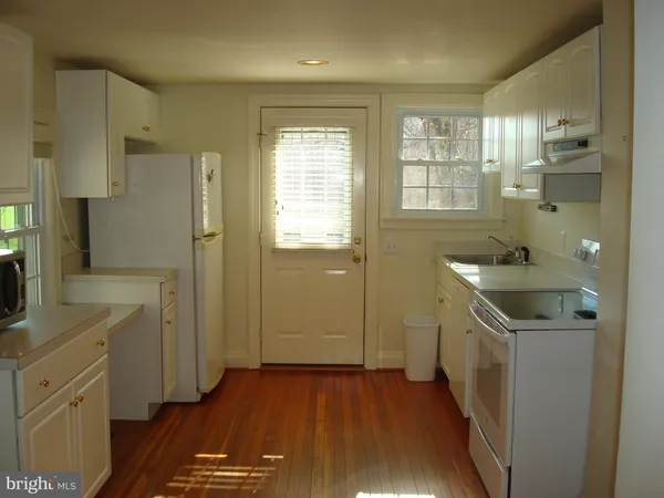 a kitchen with a sink a refrigerator and wooden cabinets