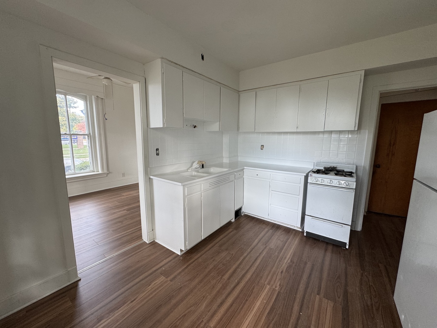 402 Joliet Street, Unit 1 West Chicago, IL 60185 - Photo 3 of 12 a kitchen with wooden floors and white appliances