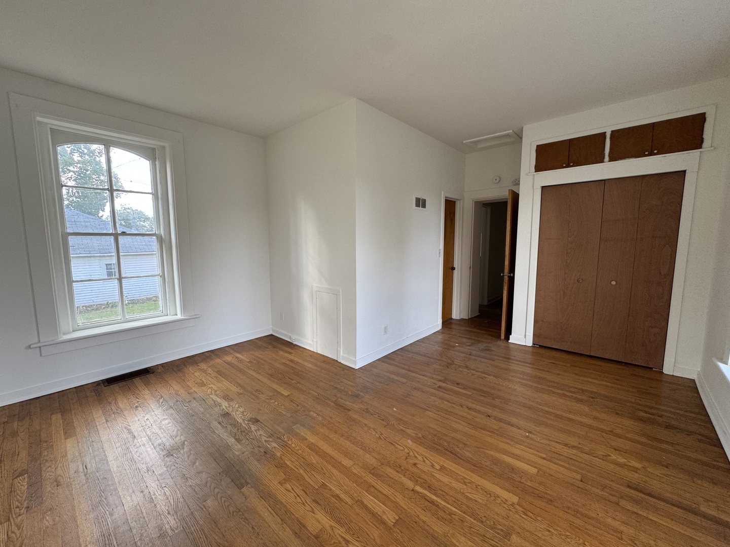 402 Joliet Street, Unit 1 West Chicago, IL 60185 - Photo 4 of 12 a view of an empty room with wooden floor and a window