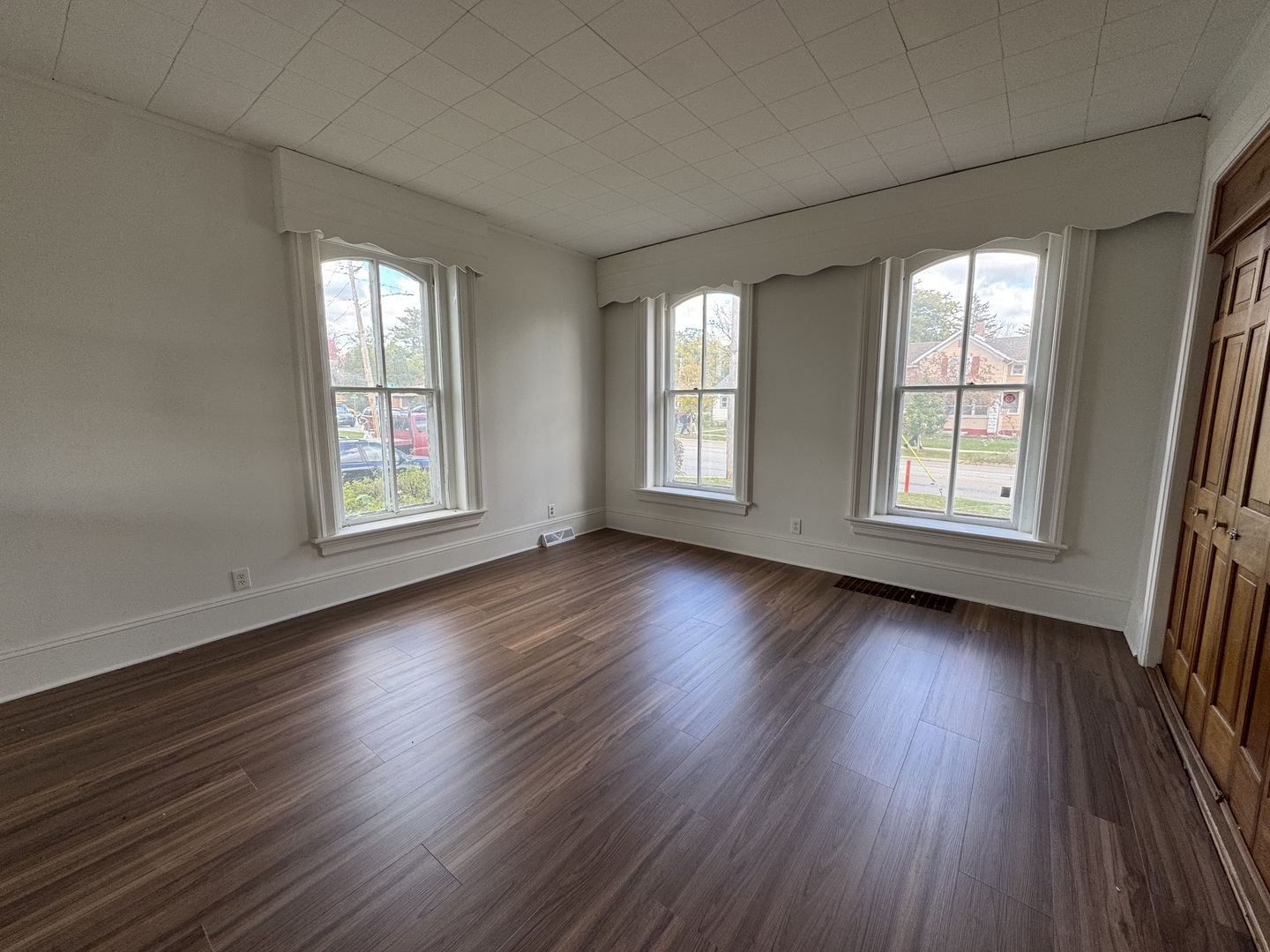 402 Joliet Street, Unit 1 West Chicago, IL 60185 - Photo 9 of 12 an empty room with wooden floor and windows