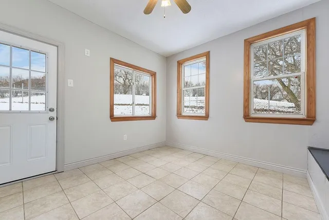 a view of an empty room with a window and a chandelier fan