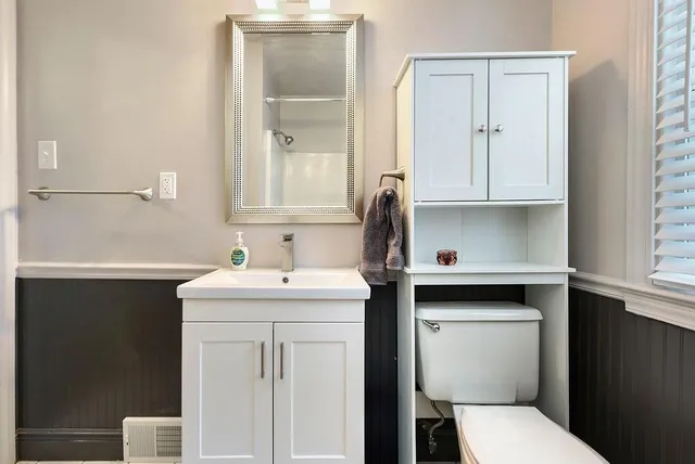 a bathroom with a toilet sink and mirror