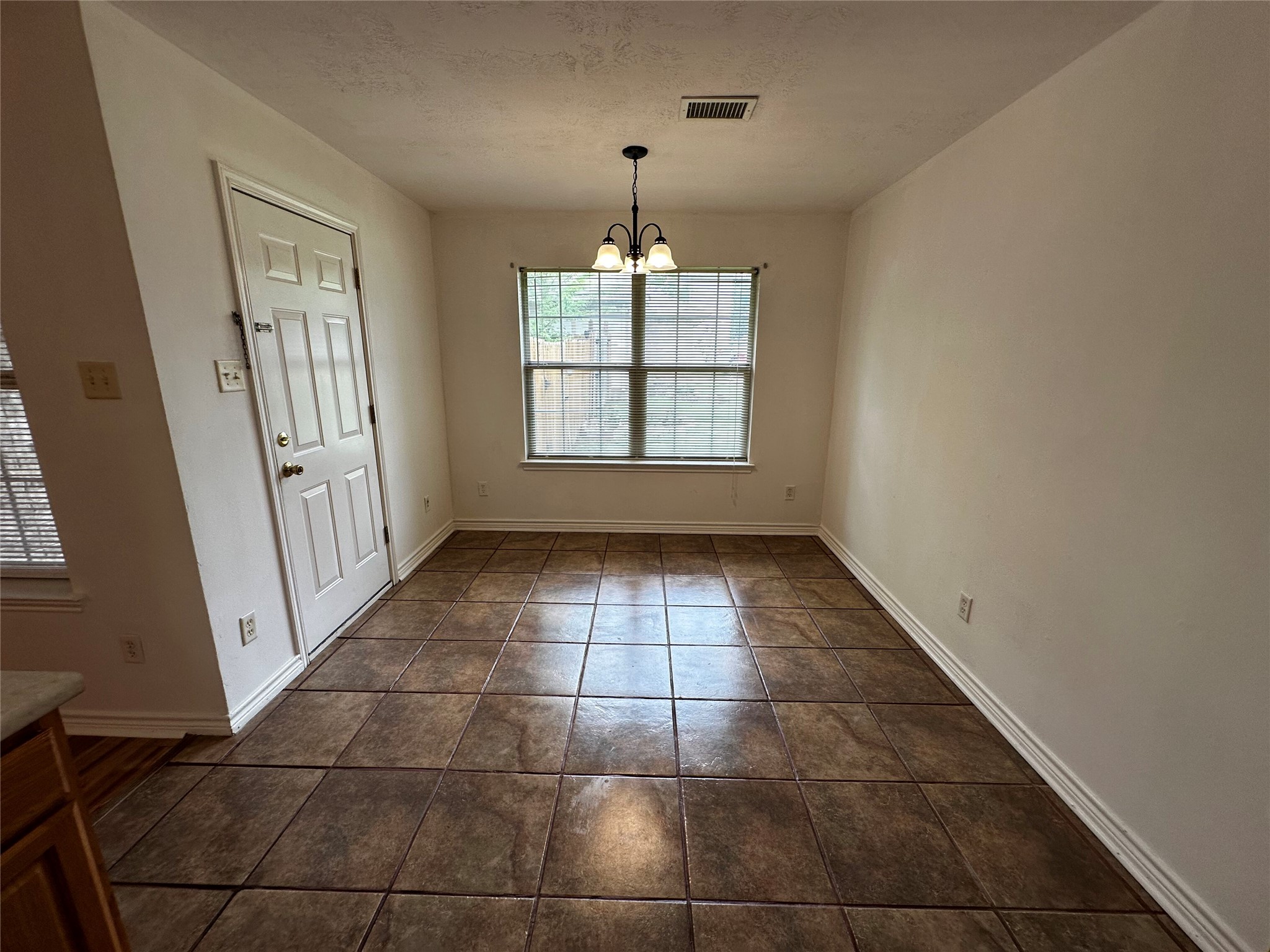 1400 Prairie Drive Bryan, TX 77802 - Photo 8 of 18 A well-lit dining area features durable tile flooring, creating a practical and inviting space for meals.