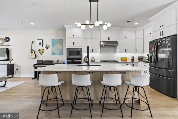 a kitchen with a stove a sink a center island and a wooden floor