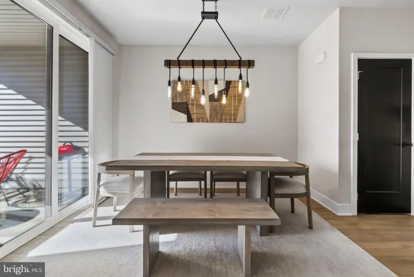 a living room with couch a dining table and a wooden floor