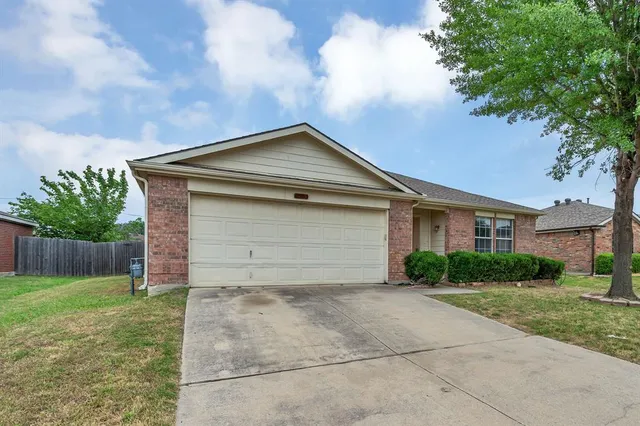 a front view of house with yard and trees around