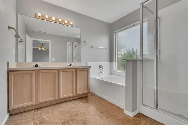 a spacious bathroom with a double vanity sink a mirror and a bathtub