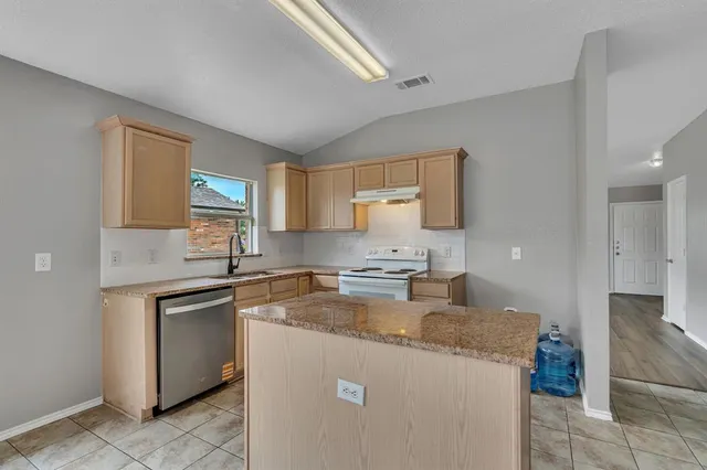 a kitchen with a stove a sink and a refrigerator