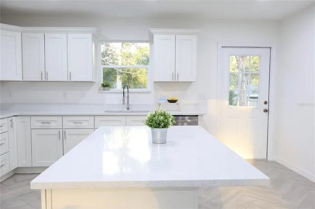 a kitchen with a white cabinets and window